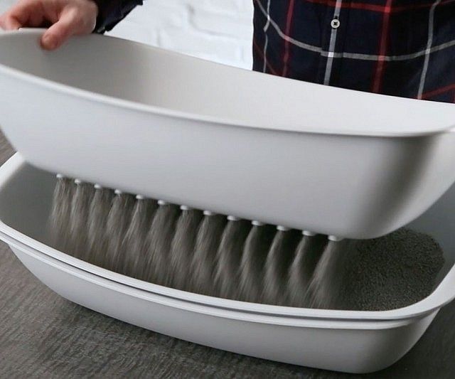 a close up of a person holding a brush in a bathtub with the lid open