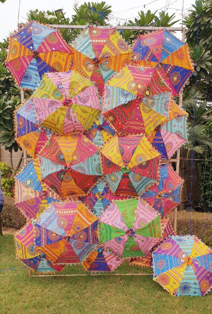 a large multicolored quilt is on display in the yard