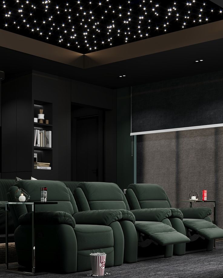 an empty theater room with green recliners and lights on the ceiling above it