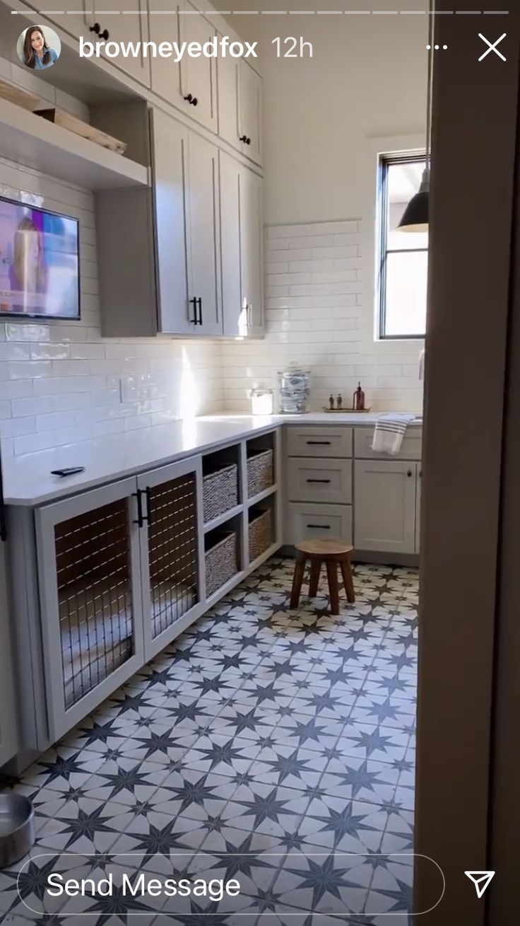 a kitchen with white cabinets and gray flooring