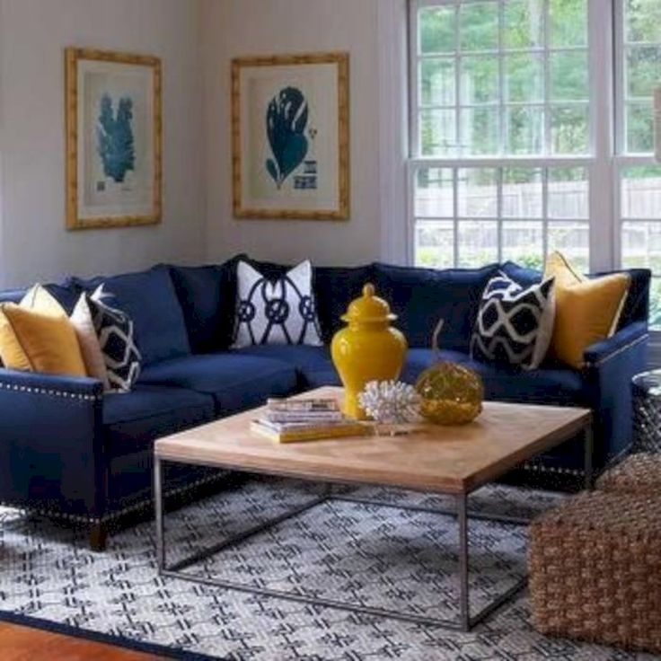 a living room with blue couches and yellow pillows