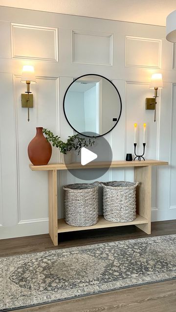 a living room with white walls and wood flooring is featured in this video about how to decorate the entryway