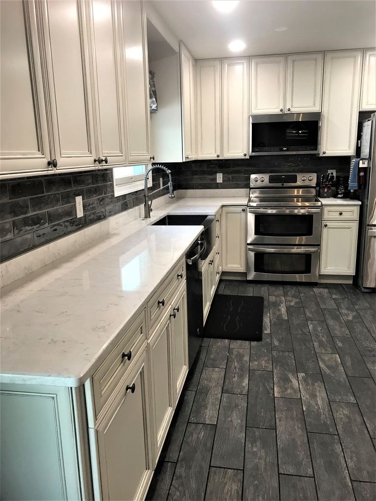 a kitchen with white cabinets and gray tile flooring is pictured in this image from the front view