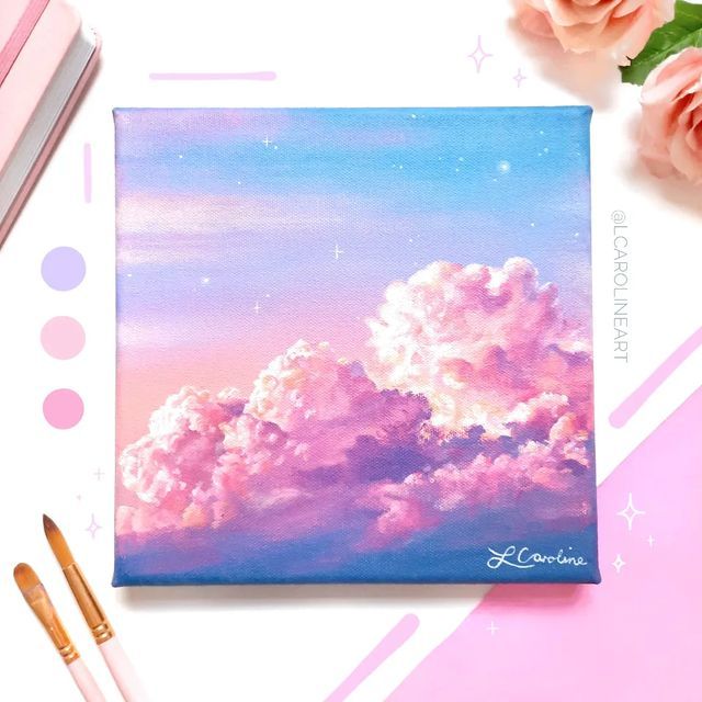 a pink and blue sky with clouds painted on it next to some paintbrushes