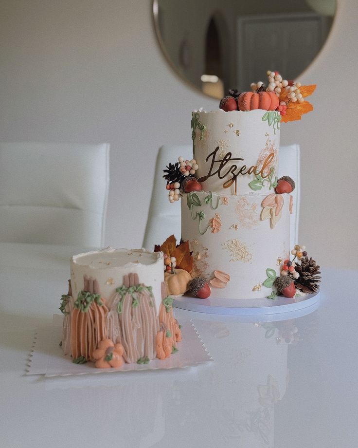 two cakes sitting on top of a white table