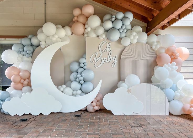 a baby shower is decorated with balloons and clouds