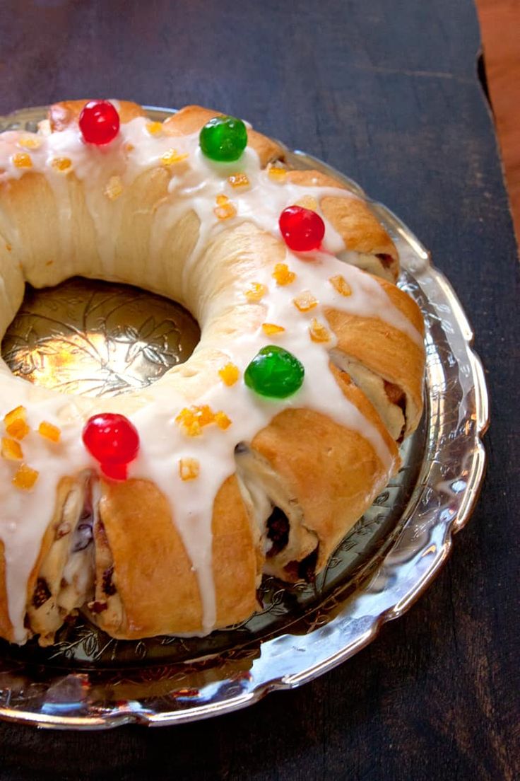 a bundt cake with white icing and gummy bears on top, sitting on a glass plate