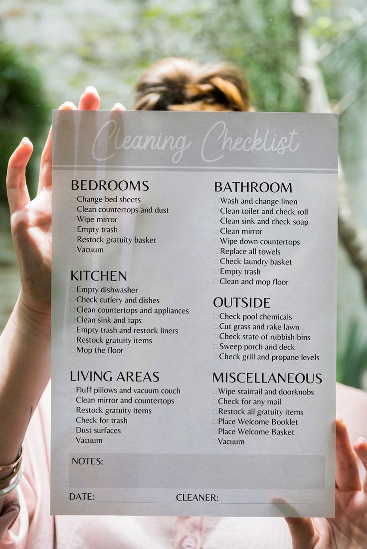 a woman holding up a cleaning checklist in front of her face with the words'cleaning checklist'written on it