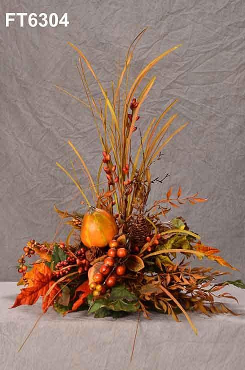 a vase filled with lots of different types of flowers and fruit on top of a table