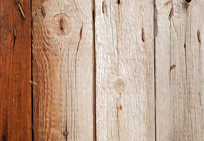 an old wood paneled wall with peeling paint on the top and bottom part showing