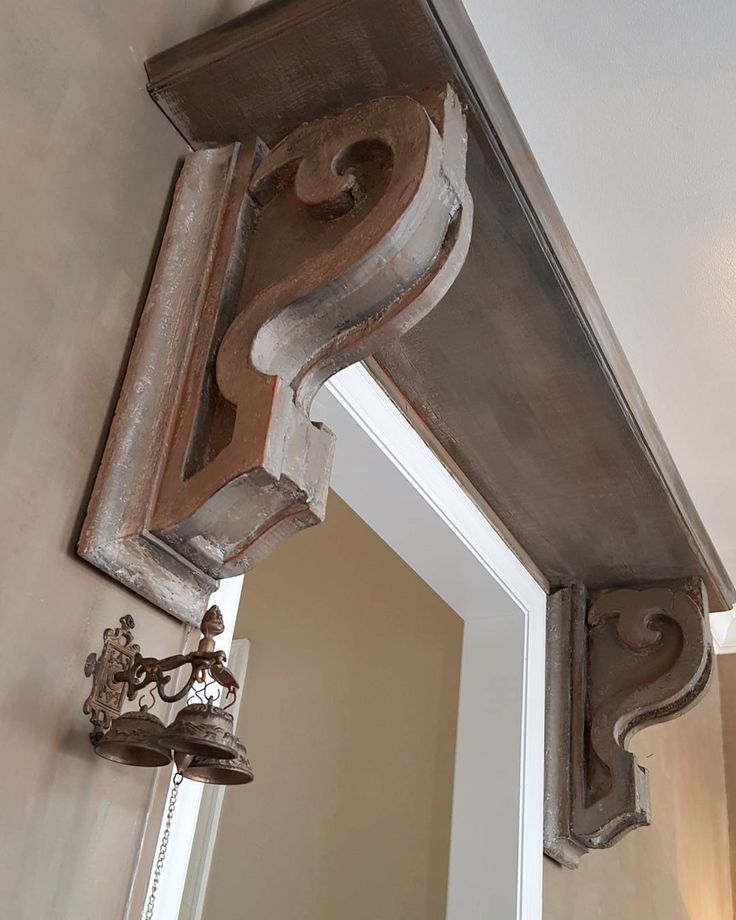 a mirror and light fixture hanging from the side of a wall next to a doorway