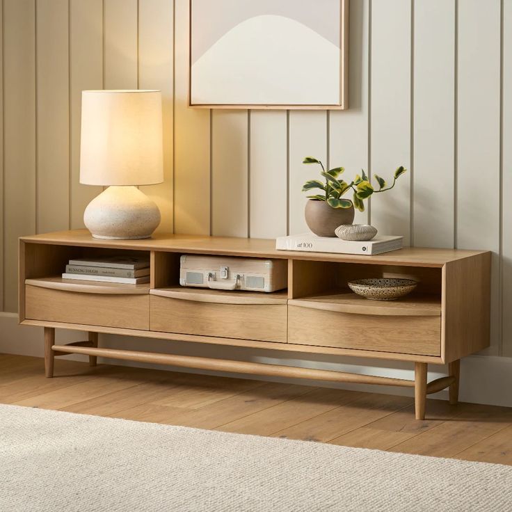 a living room scene with focus on the sideboard and vases sitting on it