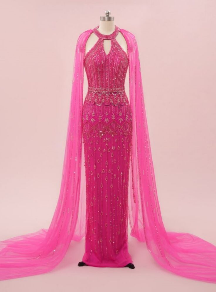 Achieve a look of timeless glamour with this exquisite hot pink prom dress, designed to make you the center of attention. The halter neckline is accentuated by intricate beadwork that flows seamlessly down the bodice, creating a stunning visual effect. The dress features a dramatic cape that cascades from the shoulders, adding a touch of regal elegance to your appearance. The form-fitting silhouette hugs your curves beautifully, ensuring you look and feel your best all night long. The vibrant color of this gown is perfect for making a bold statement, ensuring you will be the highlight of the evening. Complement this stunning dress with minimal accessories and an elegant updo to let the dress shine. This gown is perfect for those who want to combine classic elegance with a touch of modern f Hot Pink Prom, Hot Pink Prom Dress, Minimal Accessories, Pink Prom Dress, Womens Prom Dresses, Pink Prom, Pink Gowns, Elegant Updo, Sleek Hairstyles