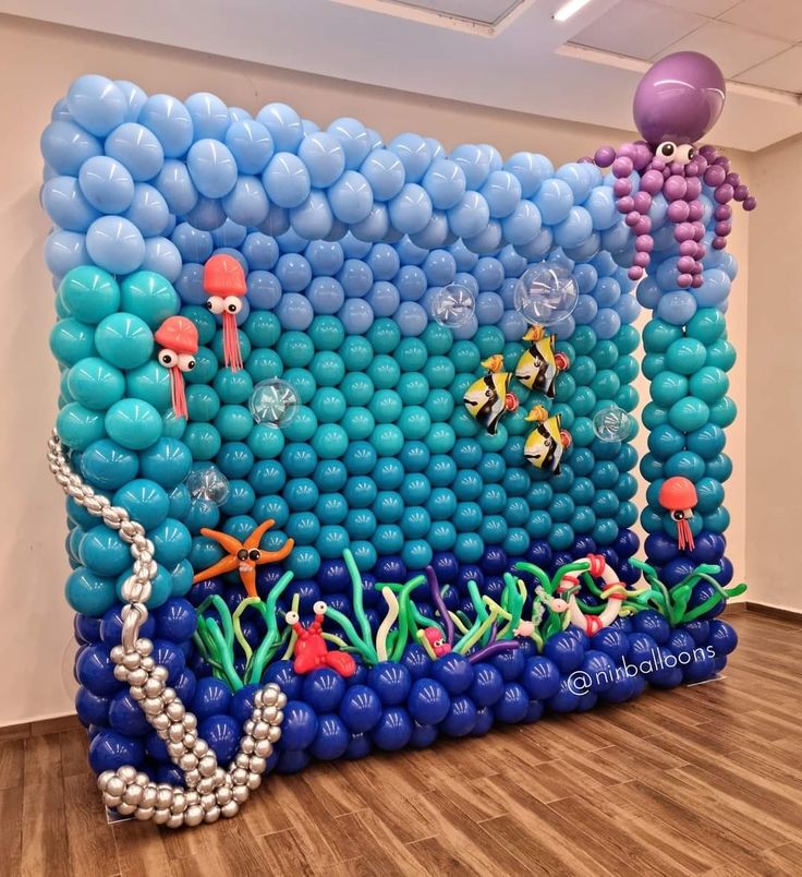 an inflatable balloon wall with balloons and sea animals on it, along with other decorations