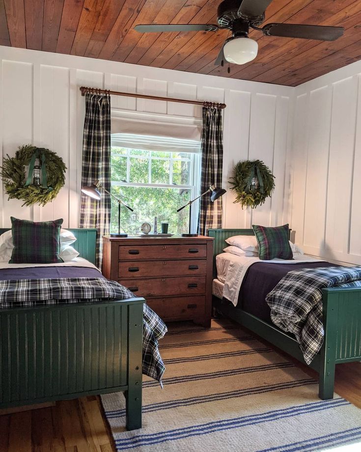 two beds in a room with wooden ceilings and plaid bedding on top of them