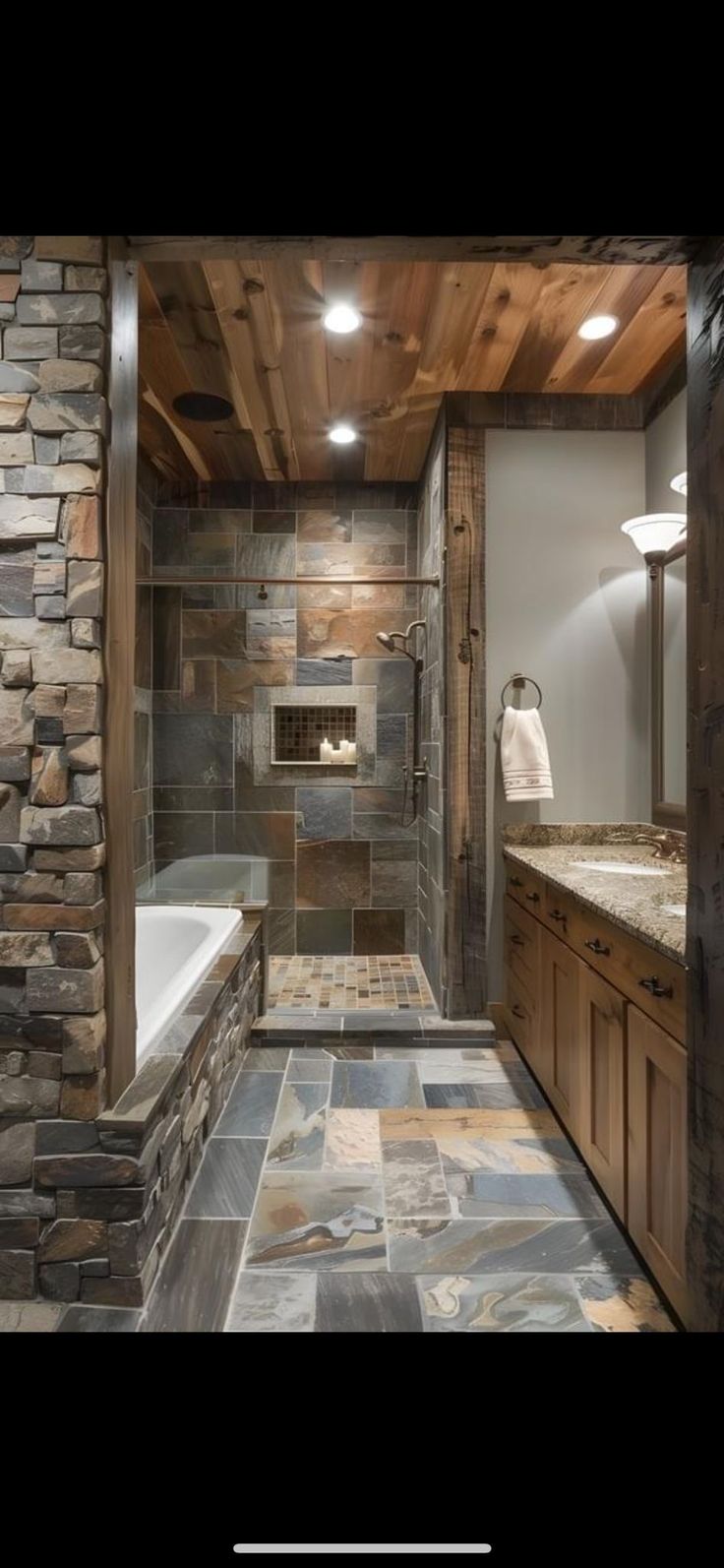 a bathroom with stone walls and flooring in the shower area, along with a bathtub