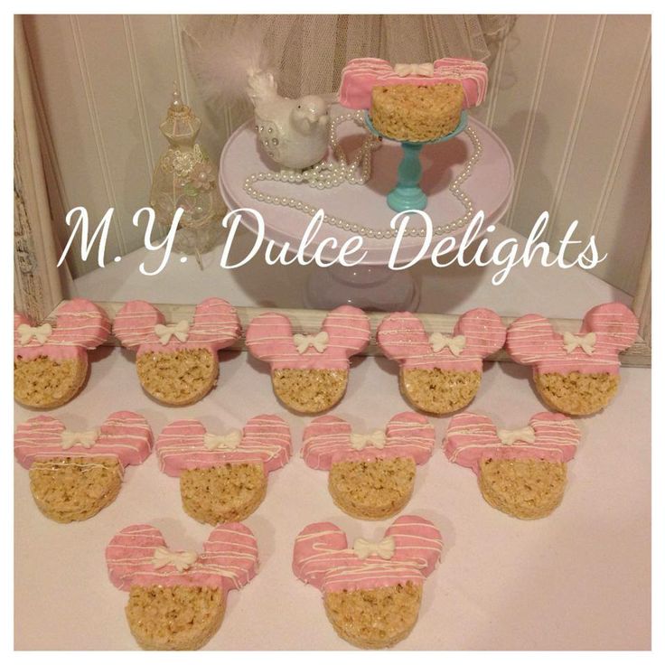 a table topped with lots of cupcakes covered in frosting and minnie mouse ears