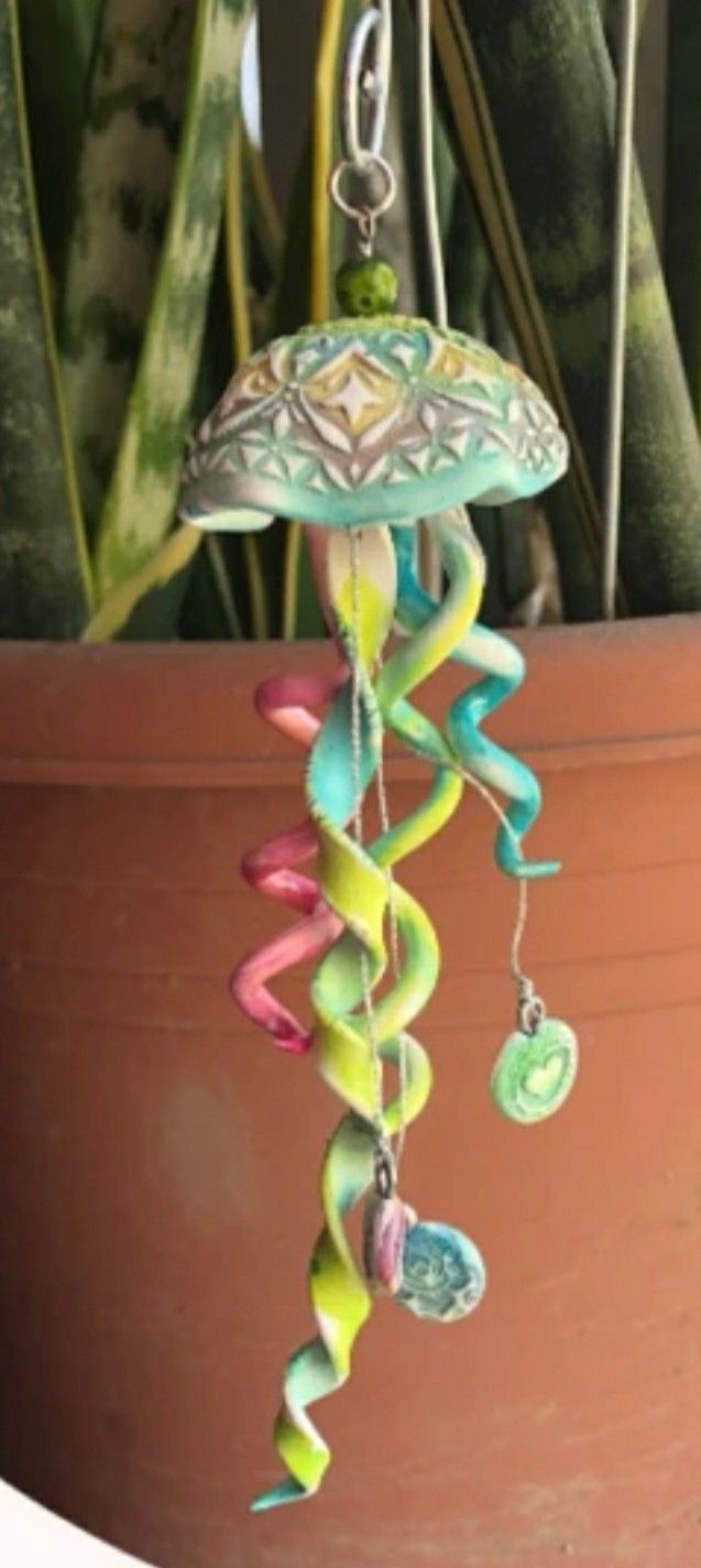 a potted plant with a wind chime hanging from it's center piece