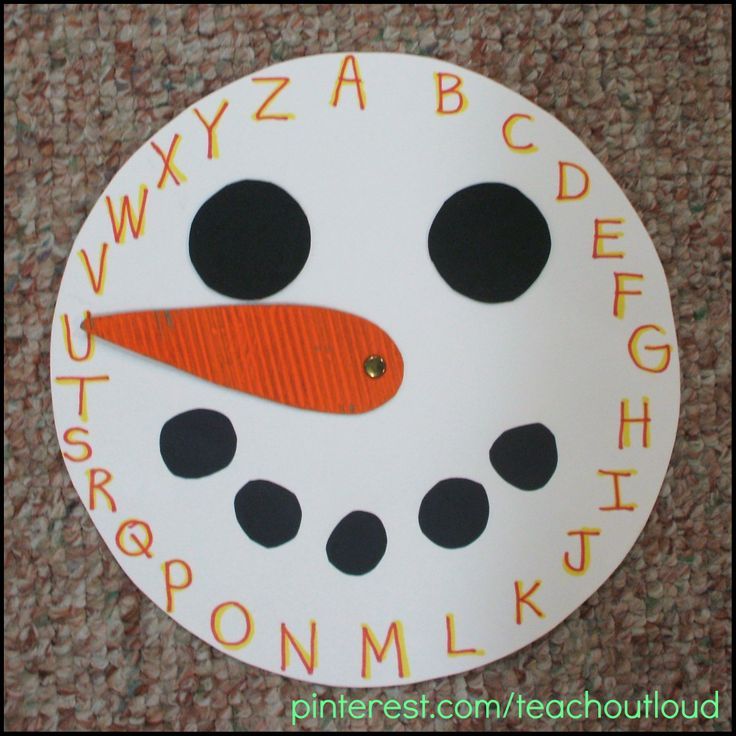 a paper snowman with letters and numbers painted on it's face, sitting on the floor