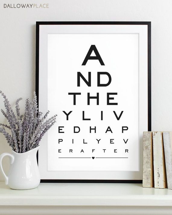 an eye chart is displayed on a shelf next to books and a vase with flowers