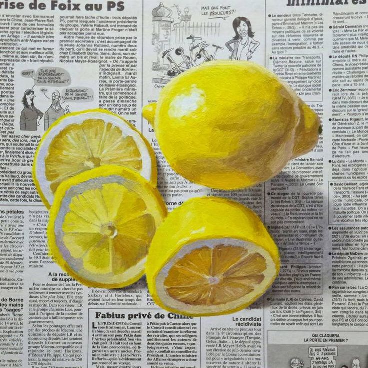 three lemons cut in half sitting on top of a newspaper