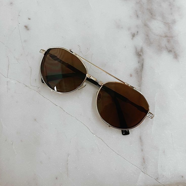 Our Gemma Retro Aviators are a great accessory to add to your wardrobe. The thick sides of the glasses add extra hardware detailing, elevating the look! Available in gold/black lens, gold/brown lens, and silver/black lens. *Each pair comes with its own soft-cloth case. Gold Aviator Sunglasses With Mirrored Lenses, Gold Aviator Sunglasses With Mirrored Lenses For Everyday, Gold Aviator Sunglasses With Polarized Lenses For Everyday, Trendy Gold Aviator Sunglasses For Everyday Wear, Gold Sunglasses With Gradient Lenses For Everyday, Trendy Gold Aviator Sunglasses, Everyday Gold Sunglasses With Metal Frame, Trendy Gold Aviator Shield Sunglasses, Gold Tinted Everyday Sunglasses