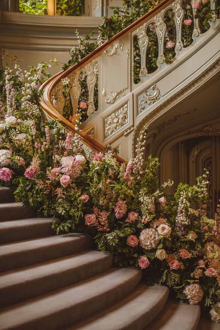 a bunch of flowers that are sitting on some kind of stair case in front of a set of stairs