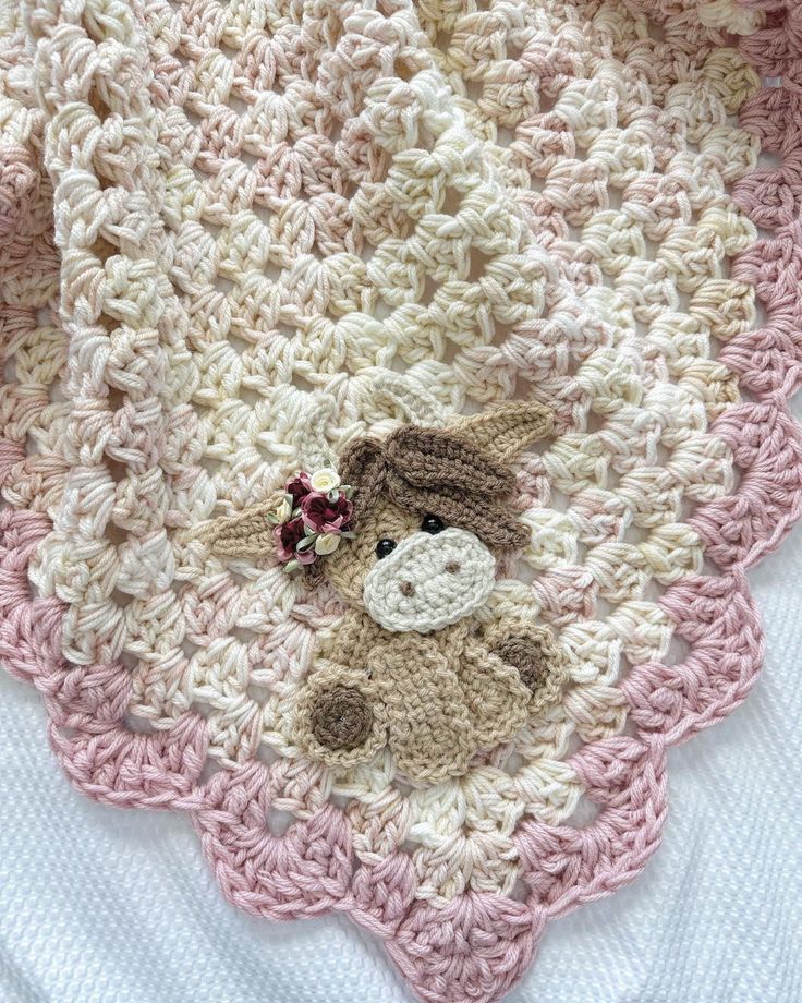 a crocheted blanket with a teddy bear on it