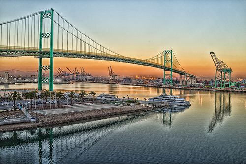 a large bridge spanning over a body of water with boats in the water below it