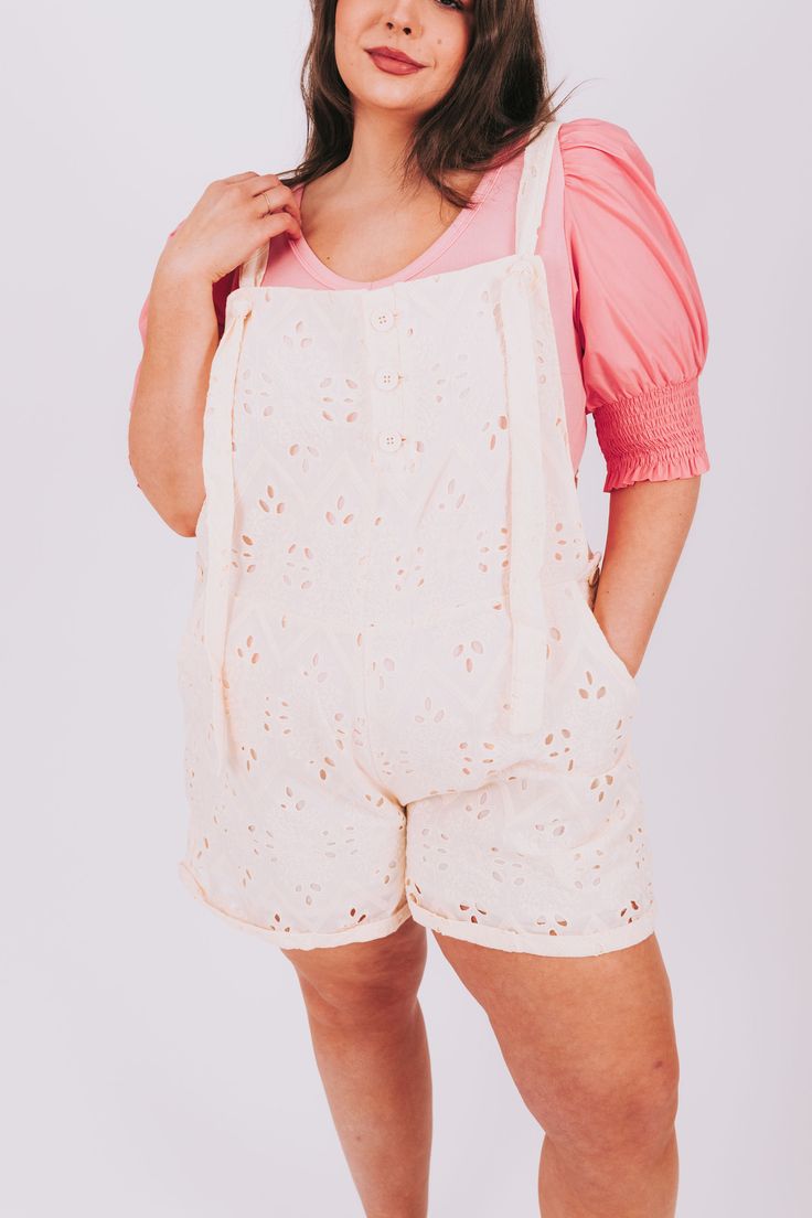 Stay cool and stylish this summer in these PLUS SIZE - Midsummer Dream Overalls. Featuring adjustable tie straps, two front pockets, and a beautiful floral eyelet fabric, these overall shorts will fit comfortably while helping you make a statement. Details Overall shorts Adjustable tie straps Eyelet fabric Pockets! Functional button front closure Functional button side closure Soft fabric Fully lined Sizing Approximate measurements: SIZE LENGTH* INSEAM WAIST 1XL 27” 3.5” 44” 2XL 28” 4” 46” 3XL 2 Summer Shortalls With Adjustable Straps, Summer Shortalls With Adjustable Straps For Spring, Cotton Summer Shortalls For Spring, Spring Shortalls With Adjustable Straps, Spring Overall Shortalls With Adjustable Straps, Spring Shortalls Overall For Day Out, Summer Cotton Shortalls For The Beach, Cotton Shortalls For Summer Vacation, Spring Shortalls For Day Out