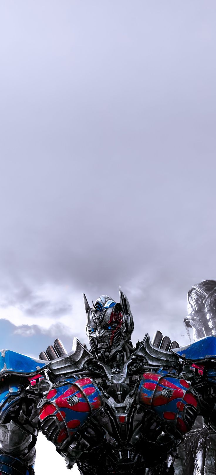 an image of a giant robot that is standing in the sky with clouds behind it