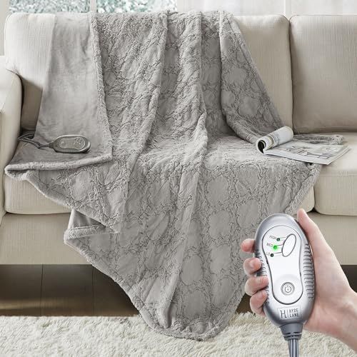 a person holding a remote control in front of a couch with a blanket on it