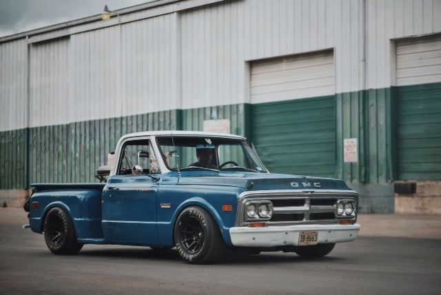 an old blue truck parked in front of a building