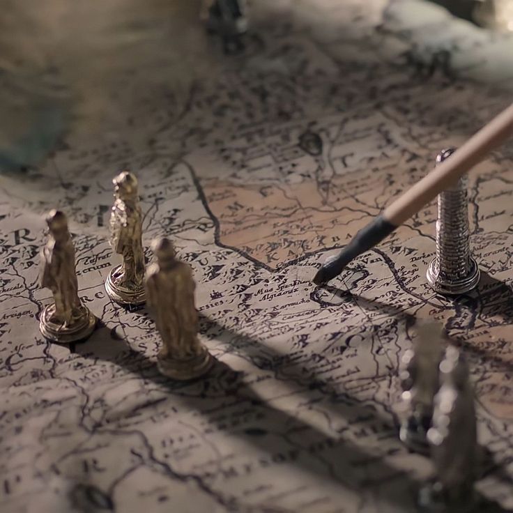 a pencil and some miniature figurines on a map