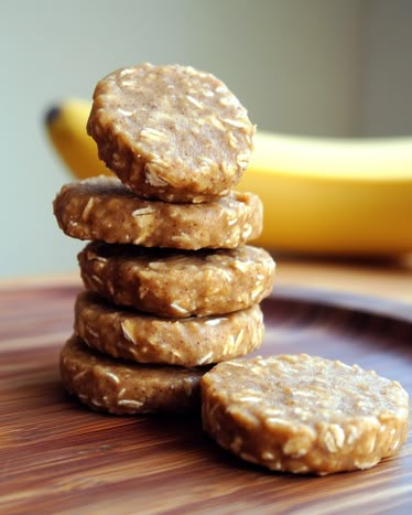 a stack of cookies sitting on top of a wooden cutting board next to a banana