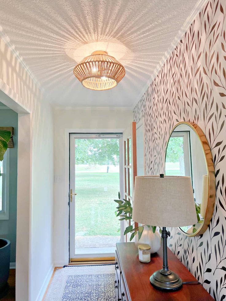 the hallway is decorated with wallpaper and a lamp on top of a wooden table