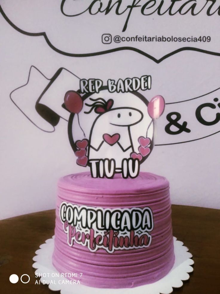 there is a pink cake that has been decorated with the words compleadors and cupcakes