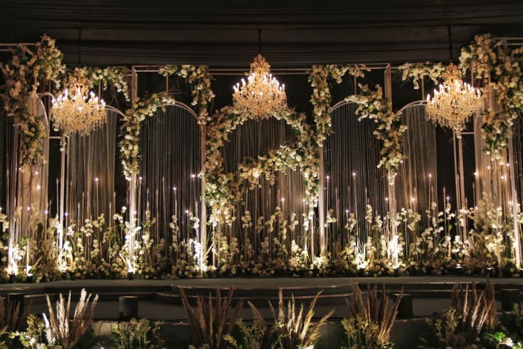 an elaborately decorated stage with chandeliers and greenery