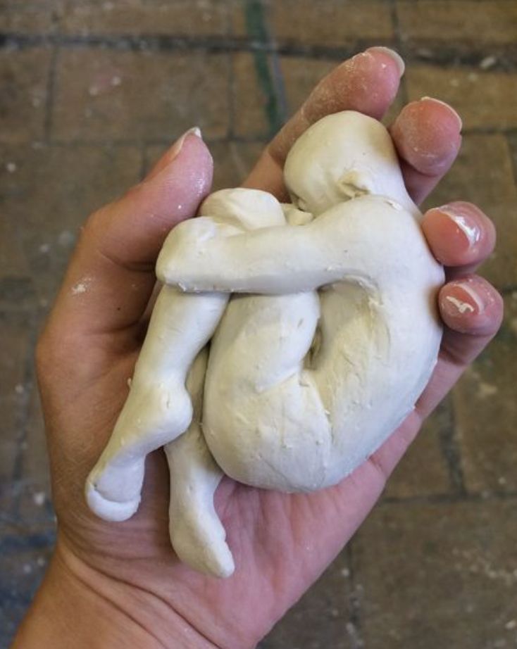 a person holding a fake human heart in their left hand with both hands on it