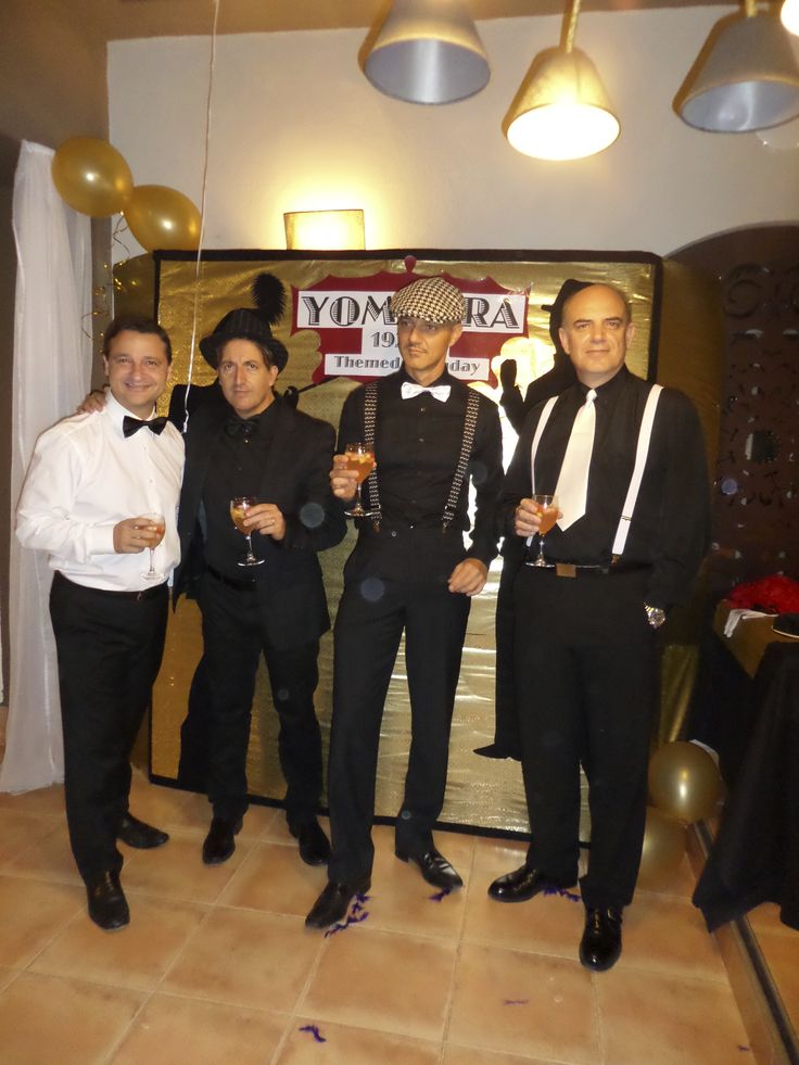 four men in tuxedos posing for a photo