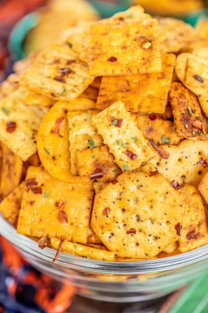 a bowl filled with cheesy crackers on top of a green table cloth