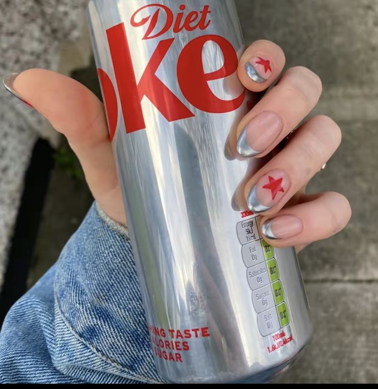 a woman holding a diet coke can with her nails and nail polishes on it