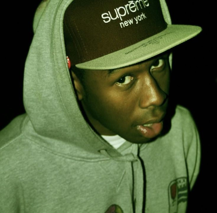 a young man wearing a supreme new york hoodie and cap with the words supreme on it