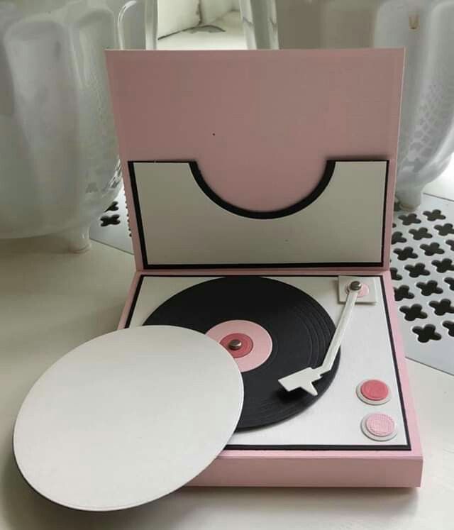 the record player is pink and white with black trims on it's sides