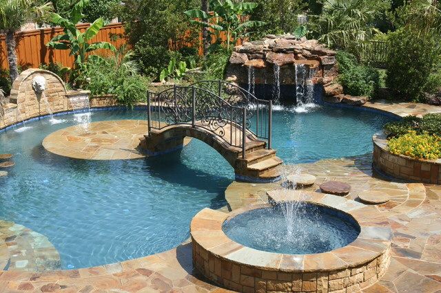 an outdoor pool with waterfall and stone steps