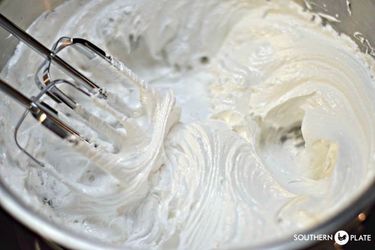 two forks in a mixing bowl full of whipped cream