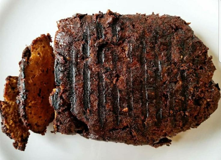 a piece of chocolate cake sitting on top of a white plate next to two pieces of bread