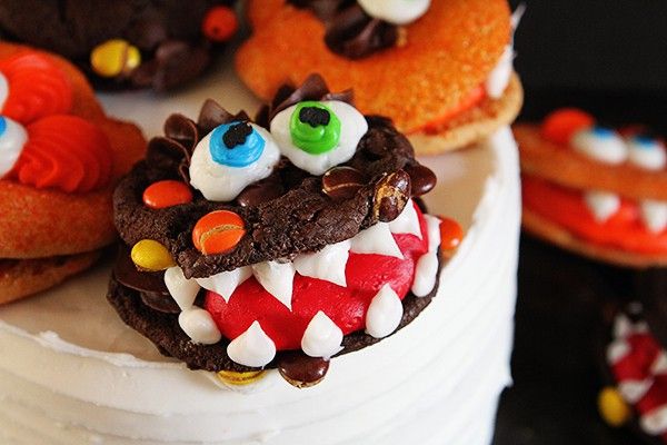 there is a cake decorated like a monster with eyes and teeth on it's face