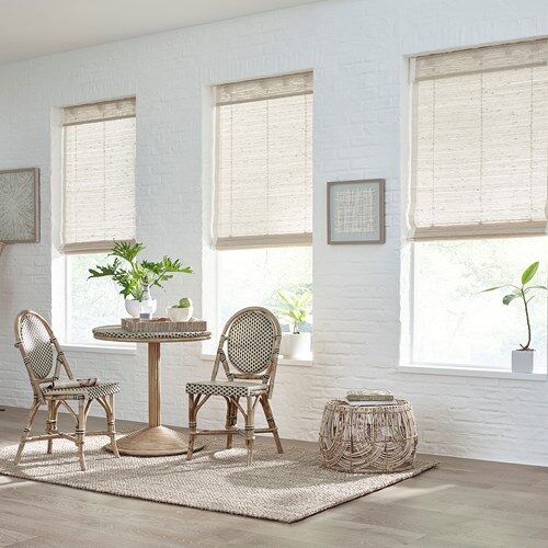 a living room filled with furniture and windows covered in shades of white brick wallpaper