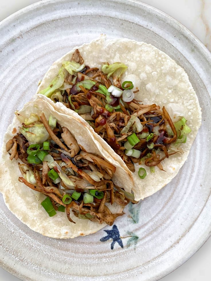 two pulled pork tacos on a plate